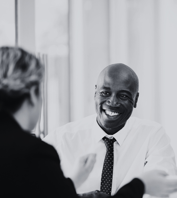 Professionals around a table laughing.